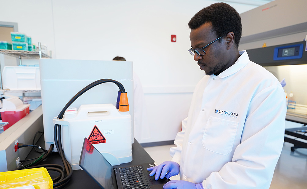 Male scientist inputting findings into laptop