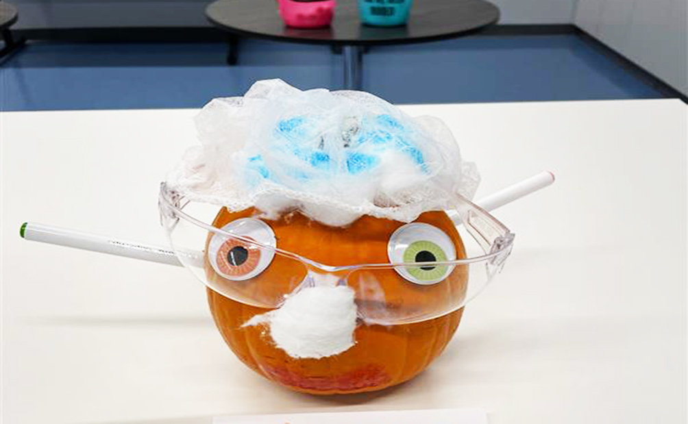 Image of a pumpkin with googly eyes glasses and other decorations, the winning pumpkin from the Lykan Bioscience employee pumpkin decorating contest.