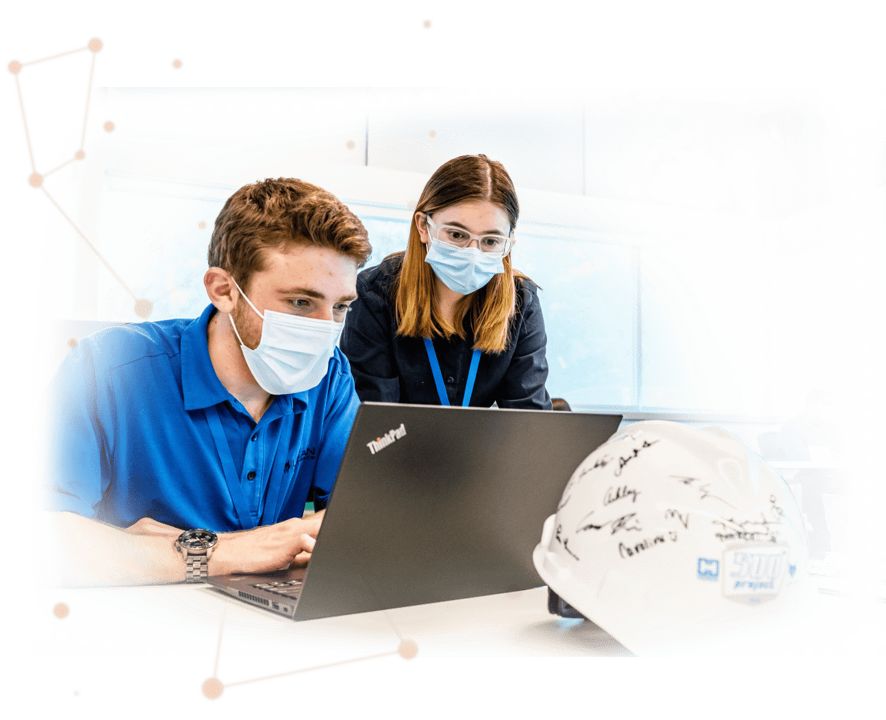 Male and female Lykan professionals looking at ThinkPad